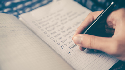 hand writing checklist in notebook
